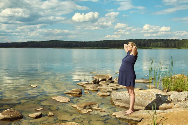 Giovane donna incinta attiva sulla riva di un lago — Foto Stock