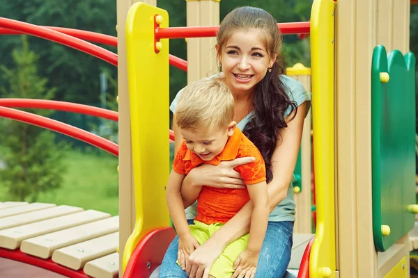 Un petit garçon sur une aire de jeux. jouer enfant avec mère sur un toboggan — Photo