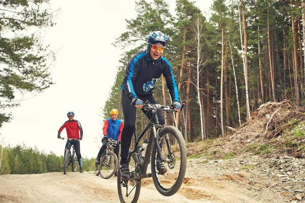 Cyclist riding a mountain bike along forest road — Stock Photo, Image