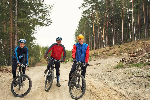 Group of cyclists on a forest road — Stock Photo, Image