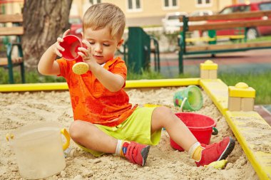 küçük çocuk oyun üzerinde. Çocuk kum havuzunda oynamayı