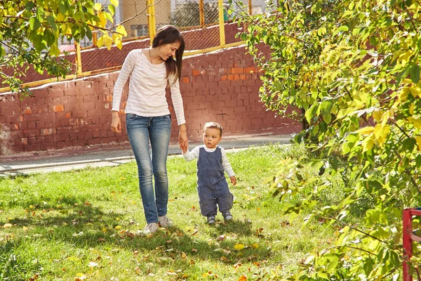 Madre joven jugando con el bebé. Mamá e hijo caminando en un parque —  Fotos de Stock