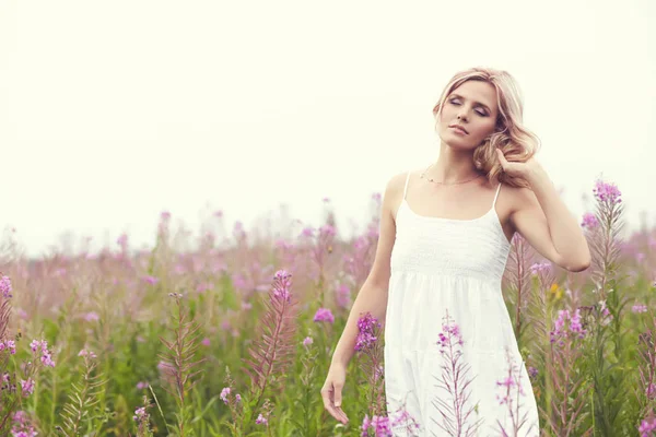 Portrait extérieur d'une femme blonde d'âge moyen. attrayant sexy fille dans un champ avec des fleurs — Photo