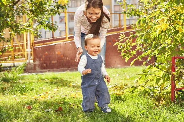 Ung mamma leker med baby. Mamma och son går i en park — Stockfoto