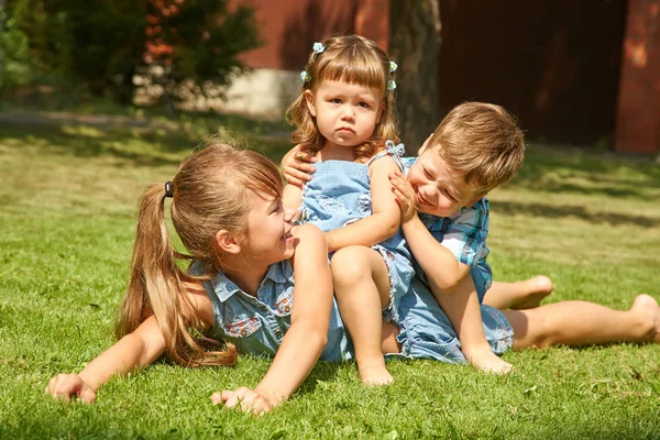 Speelse kinderen buiten in de zomer op het gras in een achtertuin — Stockfoto