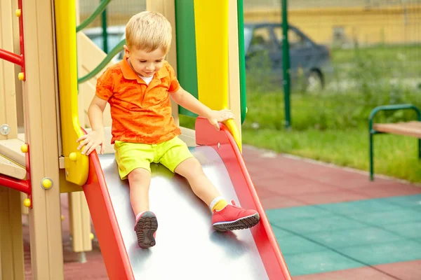 Active little boy on slide on playground — Stock Photo, Image