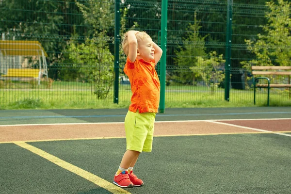 Pequeno menino ativo jogando no playground no verão — Fotografia de Stock