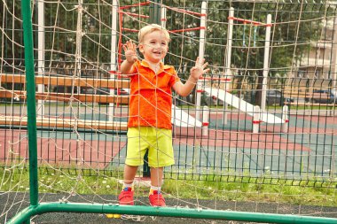 futbol kapısı bir ızgara ile oyun alanında küçük çocuk