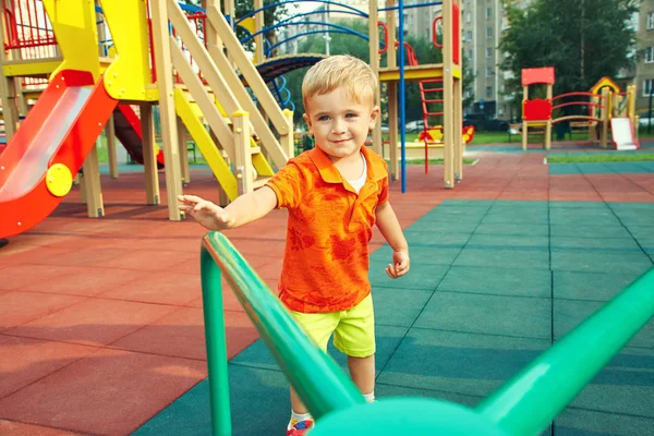 Ragazzino al parco giochi. bambino che gioca con giostra — Foto Stock