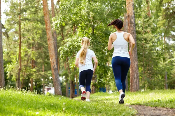 Running mother and daughter. woman and child jogging in a park. outdoor sports and fitness family — Stock Photo, Image