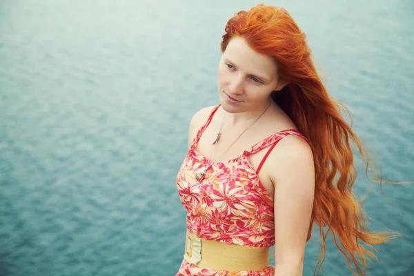 Романтична руда молода жінка в сукні на узбережжі моря — стокове фото