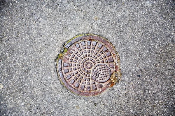 Kleine riool Luik in asfalt weg. metalen detail langs de weg. — Stockfoto