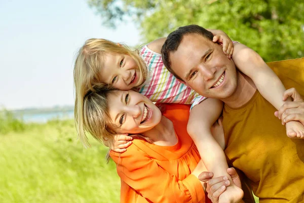 Portrét šťastné hrací rodiny venku. rodiče s dcerou v létě. Máma, táta a dítě — Stock fotografie