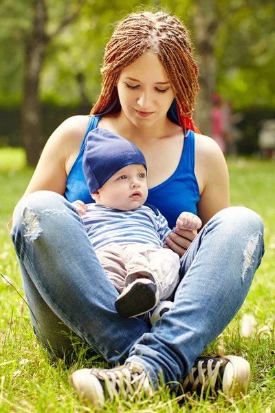 Junge Mutter spielt mit ihrem Baby. Mutter und Sohn im Park — Stockfoto