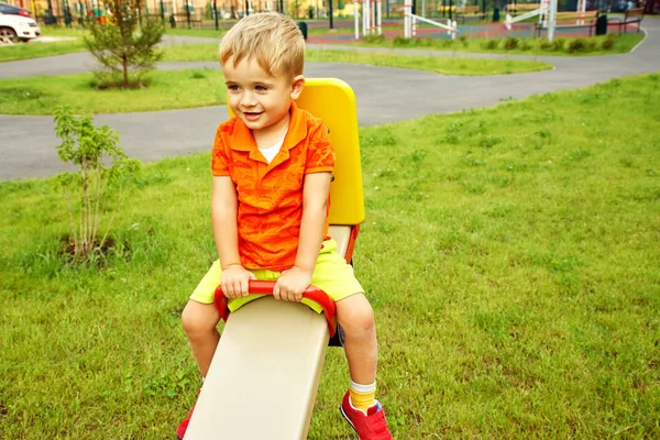 遊び場で面白い小さな男の子。ブランコで子供を遊ぶ — ストック写真