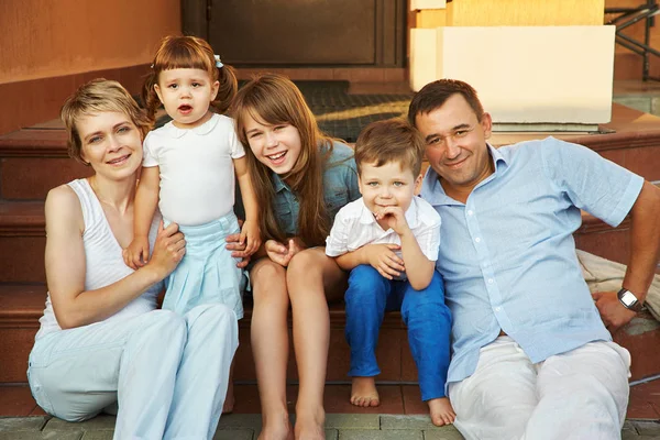 Lycklig lekfull familj på verandan i sitt hus. föräldrar med barn. Mamma, Pappa och barn — Stockfoto