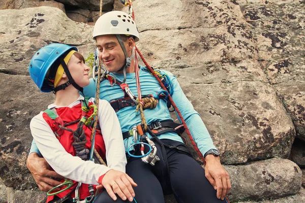 Jovem casal em alpinistas apaixonados. homem e mulher pendurados numa pedra nas cordas. escalada, esporte extremo — Fotografia de Stock