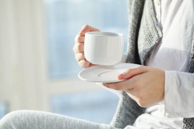 Bir fincan sabah kahvesi ya da çayı olan kadın. eller yakın.