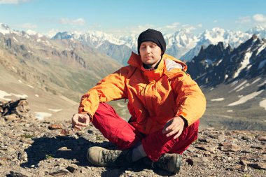 dağcı dağların arka planda meditasyon. rahat adam açık havada