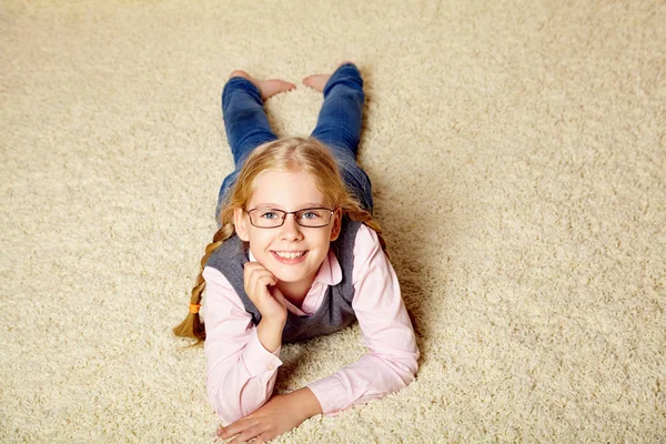 Portret van een schoolmeisje met een bril. kind thuis. — Stockfoto