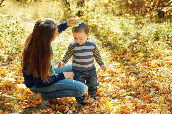 Ritratto all'aperto di una giovane madre con il suo bambino. Mamma e figlio in un parco autunnale . — Foto Stock