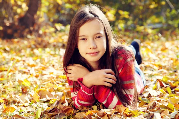 Portrait d'une belle adolescente souriante aux feuilles jaunes en automne . — Photo