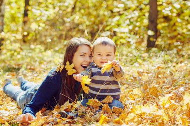 yürüyüş ve bebeği ile genç anne oynarken açık havada. Anne ve oğlu bir sonbahar parkında.