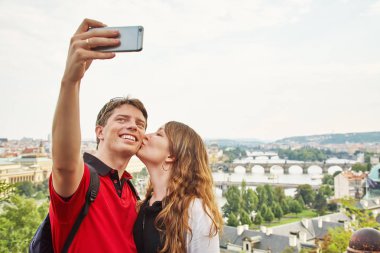 Aşık genç çift Avrupa şehrinin bir sokakta yürüyor. selfie fotoğrafı çeken gezi gezgini