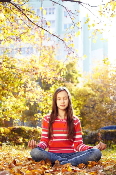 Teenage girl meditating in the autumn park — Stock Photo, Image