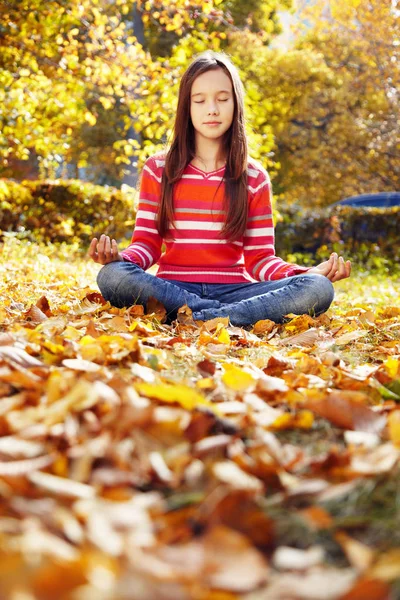 Tiener meisje mediteren in het herfst Park — Stockfoto