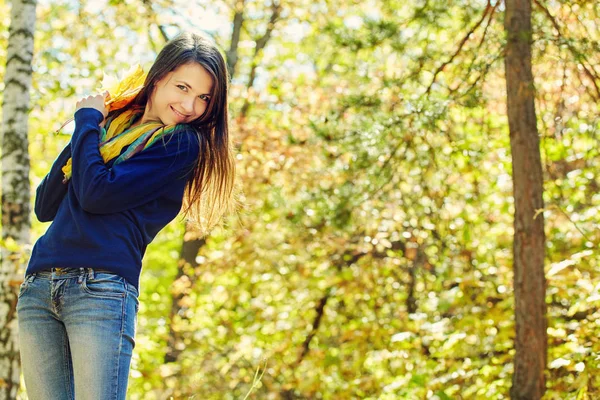 Frau mit gelben Ahornblättern im Herbst — Stockfoto