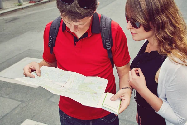 ヨーロッパの街の通りを歩く恋の若いカップル。地図付き観光旅行者 — ストック写真