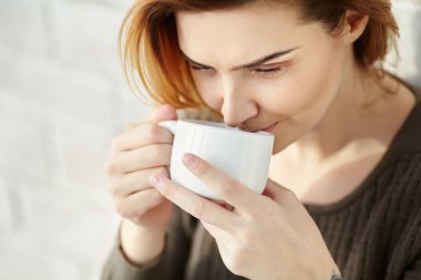 sabah kahve si veya çay bir fincan genç çekici gülümseyen kadın portresi.