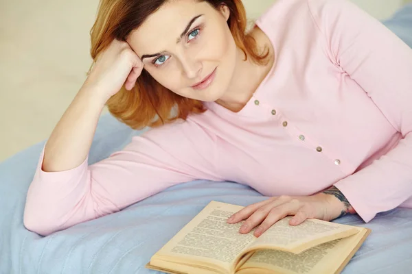 Молода жінка на ліжку з книгою. дівчина читає вдома . — стокове фото