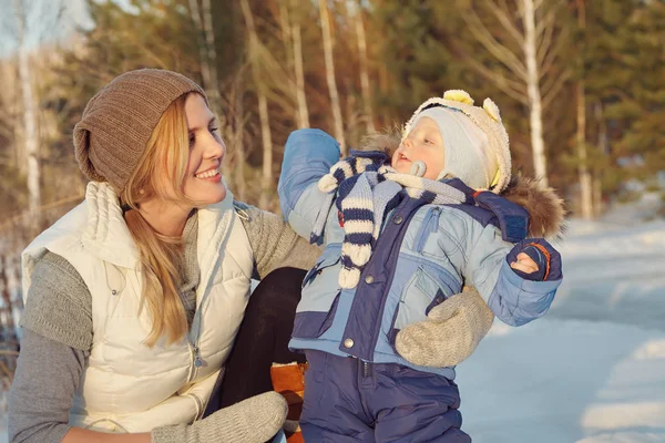 Szczęśliwą matką i dzieckiem w winter park. rodziny na zewnątrz. wesoły mama z dzieckiem. — Zdjęcie stockowe