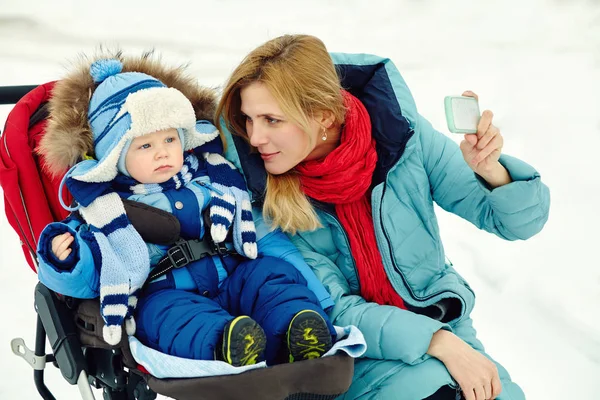 Happy mother and baby in winter. family outdoors. cheerful mommy with her child. — Stock Photo, Image