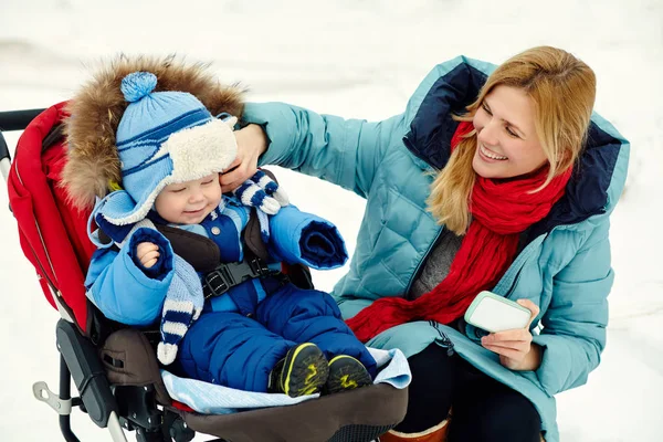 Happy mother and baby in winter. family outdoors. cheerful mommy with her child. — Stock Photo, Image