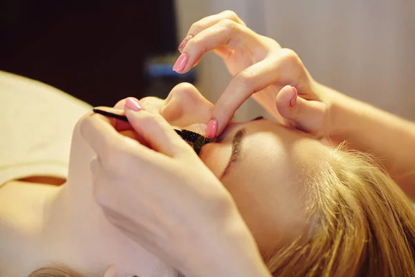 beautician making artificial lashes. eyelash extension procedure.