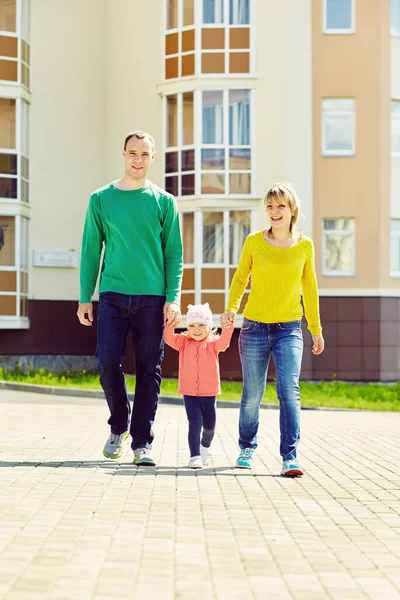 Glad att leka familj utomhus. unga föräldrar med ett barn som går på sommaren. Mamma, pappa och barn. — Stockfoto