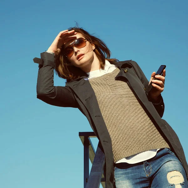 Retrato al aire libre de una mujer elegante con teléfono inteligente. mujer de negocios en una calle. — Foto de Stock