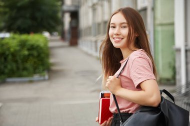 Sırt çantalı ve eğitim aletli bir kız. Üniversiteye yakın öğrenci.