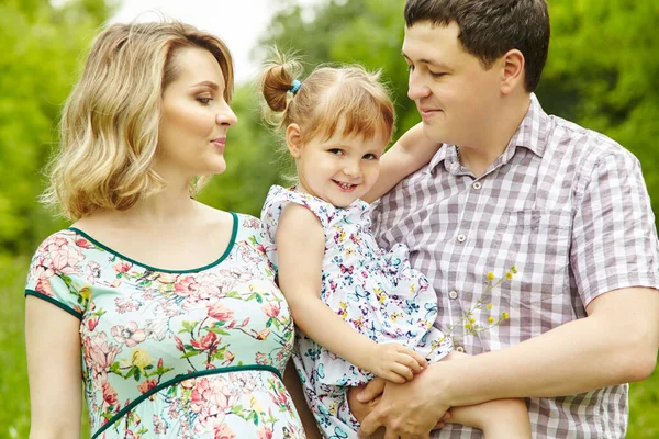 Porträt einer glücklichen Spielfamilie im Freien. junge Eltern mit Tochter im Sommer. Mutter, Vater und Kind. — Stockfoto