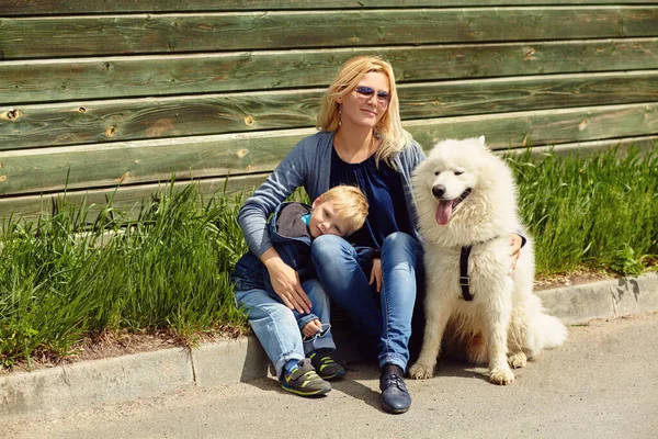 Outdoor portret moeder, zoon en hond. kind en mam wandelen samoyed laika. — Stockfoto