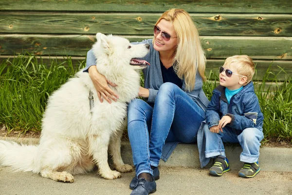 Mutter, Sohn und Hund im Freien. Kind und Mutter gehen samoyed laika. — Stockfoto