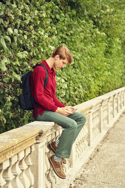 Snygg ung man som använder surfplatta. student med ryggsäck. — Stockfoto