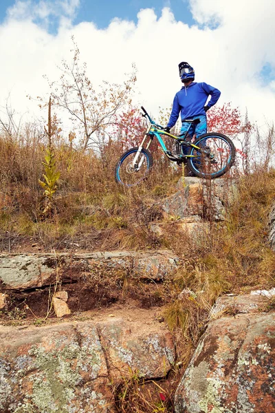 Hombre en casco con una bicicleta de montaña cuesta abajo . — Foto de Stock