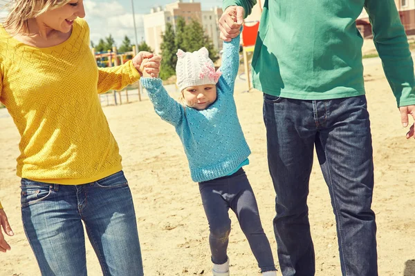 Glad att leka familj utomhus. unga föräldrar med ett barn som går på sommaren. Mamma, pappa och barn. — Stockfoto