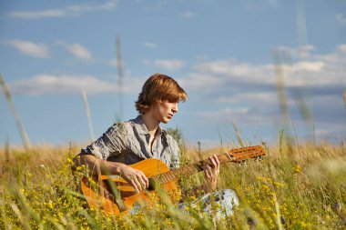 Akustik gitarlı yakışıklı genç bir adam..