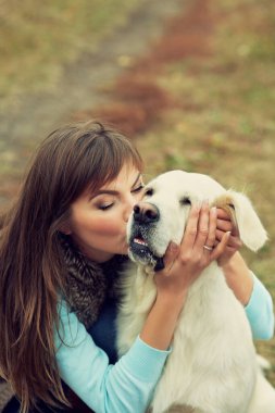 Golden Retriever sahibiyle yürüyüşe çıktı. Açık havada bir kadınla labrador çifti.