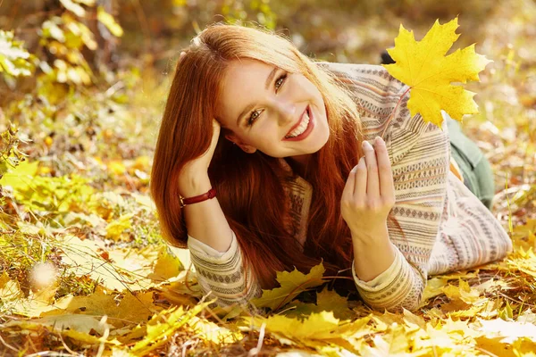 Kvinna med gula lönnlöv på hösten — Stockfoto
